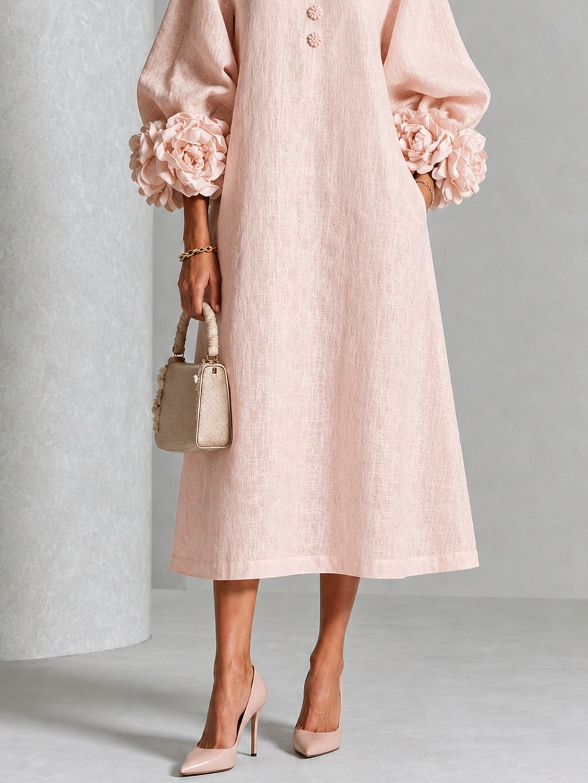 Liv | Rosa midi-kjole med blomsterknapper og markante blomstermanchetter